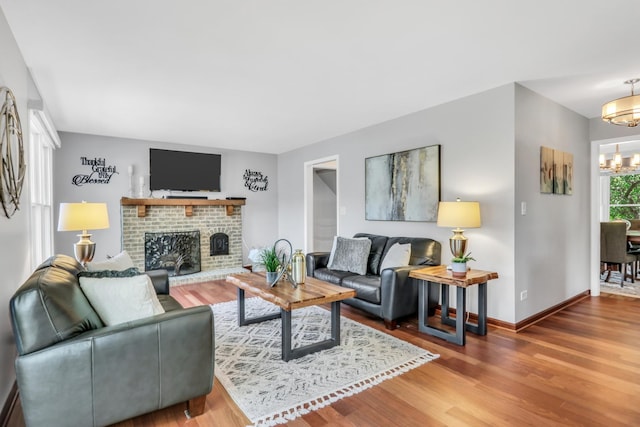 347 Yorkshire Dr, Mundelein, IL 60060 - living area with a chandelier, wood finished floors, a brick fireplace, and baseboards