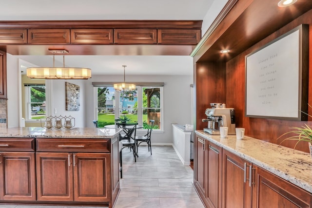 347 Yorkshire Dr, Mundelein, IL 60060 - kitchen with light stone countertops, pendant lighting, baseboards, and a chandelier
