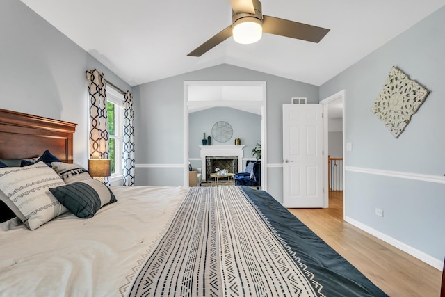 347 Yorkshire Dr, Mundelein, IL 60060 - bedroom featuring wood finished floors, lofted ceiling, a ceiling fan, baseboards, and a fireplace