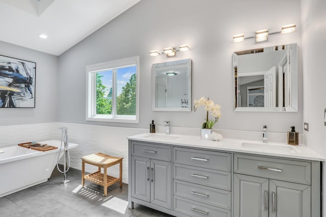 347 Yorkshire Dr, Mundelein, IL 60060 - bathroom with vaulted ceiling, tile patterned floors, double vanity, a freestanding bath, and tile walls