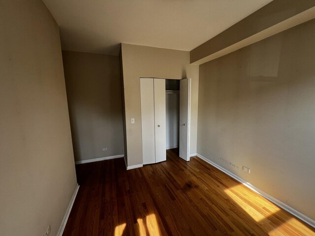 7513 N Winchester Ave Unit 1, Chicago, IL 60626 - unfurnished bedroom with wood finished floors, baseboards, and a closet