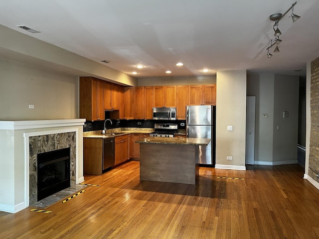 7513 N Winchester Ave Unit 1, Chicago, IL 60626 - kitchen with appliances with stainless steel finishes, a sink, wood-type flooring, a kitchen island, and backsplash