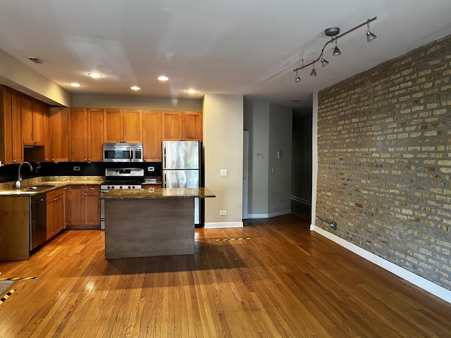 7513 N Winchester Ave Unit 1, Chicago, IL 60626 - kitchen featuring stainless steel appliances, a sink, hardwood / wood-style flooring, baseboards, and a kitchen island