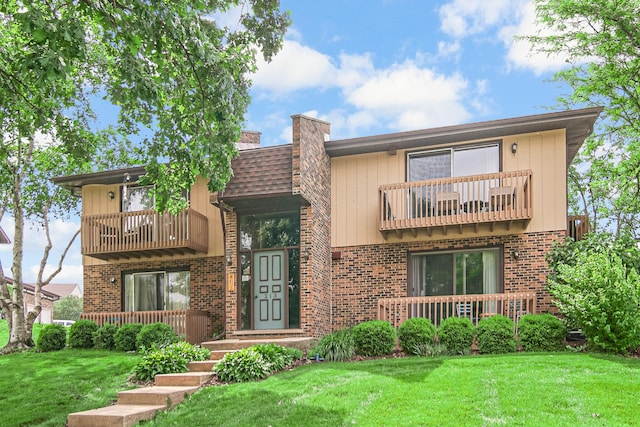 213 Vine St Unit 3, New Lenox, IL 60451 - view of front of property featuring a balcony, a chimney, a front lawn, and brick siding