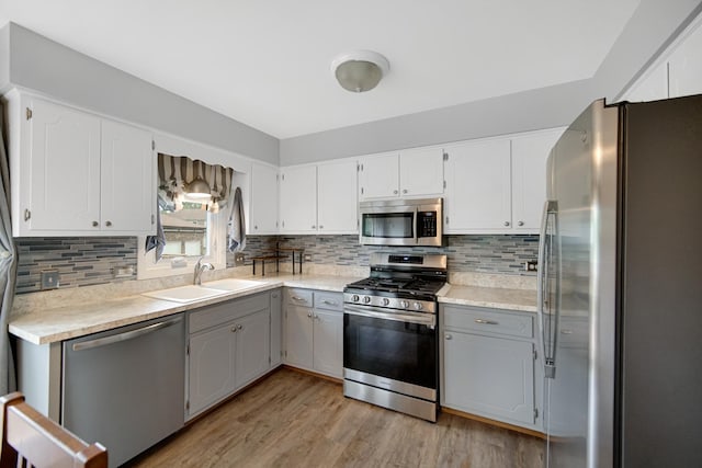 213 Vine St Unit 3, New Lenox, IL 60451 - kitchen with appliances with stainless steel finishes, a sink, light wood finished floors, gray cabinetry, and backsplash