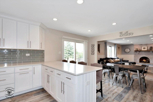 8456 Meadows Edge Trl, Tinley Park, IL 60487 - kitchen featuring open floor plan, light countertops, a peninsula, a breakfast bar, and white cabinetry