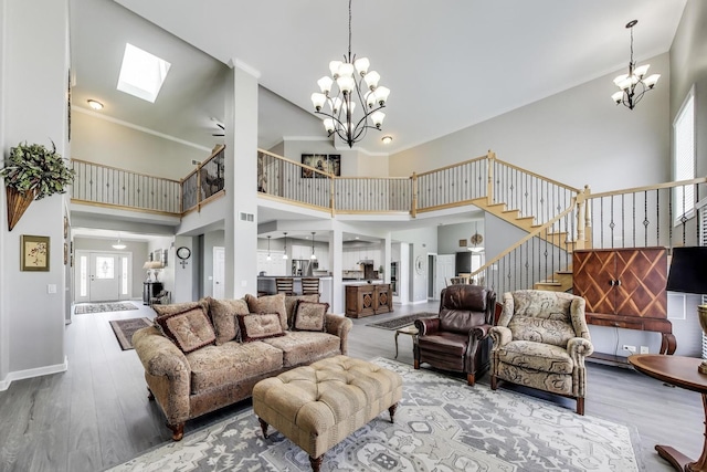 27117 Ashgate Xing, Plainfield, IL 60585 - living room featuring a chandelier, stairs, wood finished floors, a skylight, and a high ceiling