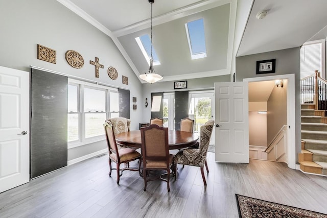 27117 Ashgate Xing, Plainfield, IL 60585 - dining space with a skylight, stairs, wood finished floors, high vaulted ceiling, and crown molding