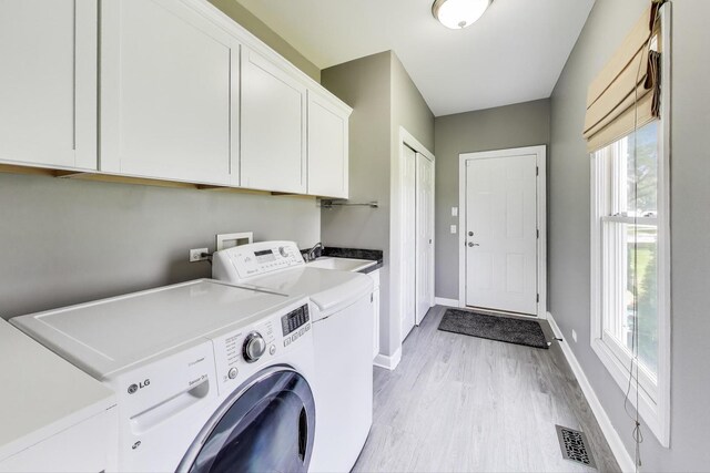 27117 Ashgate Xing, Plainfield, IL 60585 - laundry area featuring cabinet space, separate washer and dryer, and light wood-style floors