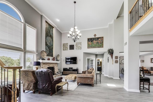 27117 Ashgate Xing, Plainfield, IL 60585 - living area with a towering ceiling, a fireplace, a chandelier, wood finished floors, and ornamental molding