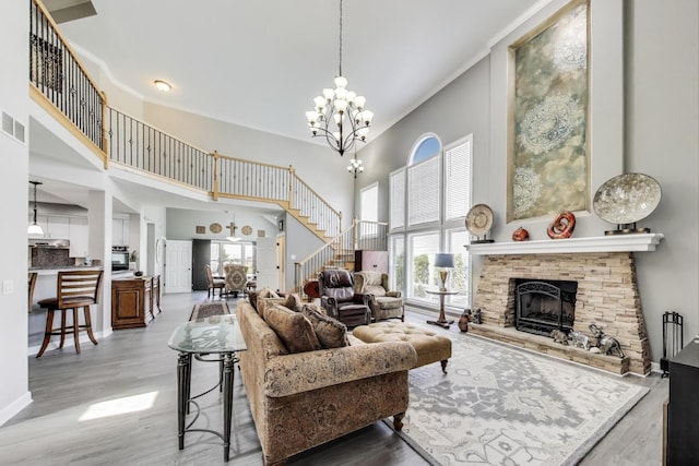 27117 Ashgate Xing, Plainfield, IL 60585 - living room with a towering ceiling, stairway, healthy amount of natural light, a stone fireplace, and a chandelier