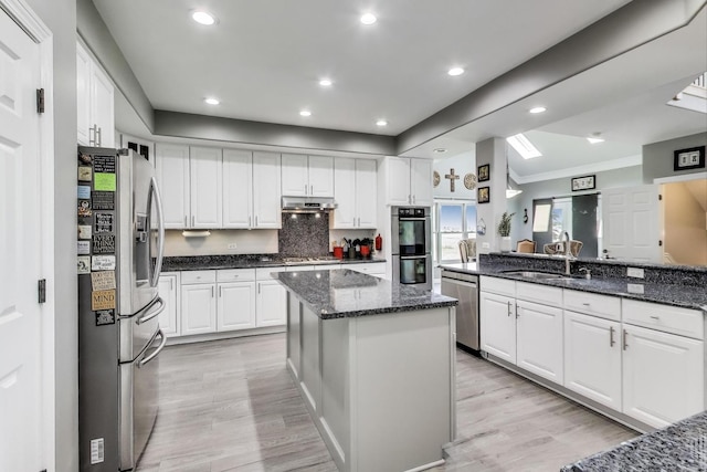 27117 Ashgate Xing, Plainfield, IL 60585 - kitchen featuring appliances with stainless steel finishes, under cabinet range hood, light wood-style flooring, white cabinetry, and ornamental molding