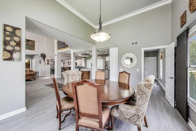 27117 Ashgate Xing, Plainfield, IL 60585 - dining area featuring a towering ceiling, light wood finished floors, and crown molding