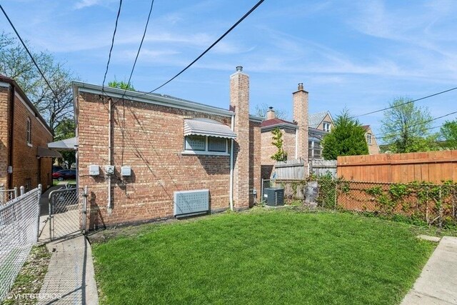3411 W 59th St, Chicago, IL 60629 - rear view of house featuring brick siding, a gate, and cooling unit
