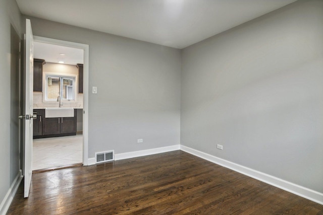 15123 Wabash Ave, South Holland, IL 60473 - empty room with wood finished floors, baseboards, and a sink