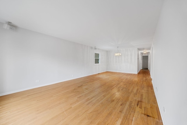 1094 E Algonquin Rd, Des Plaines, IL 60016 - empty room with light wood finished floors, a chandelier, and baseboards
