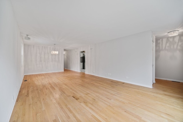 1094 E Algonquin Rd, Des Plaines, IL 60016 - empty room featuring a chandelier, light wood finished floors, and baseboards