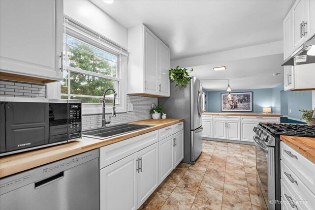 688 Regent Dr, Crystal Lake, IL 60014 - kitchen featuring wooden counters, appliances with stainless steel finishes, decorative backsplash, white cabinets, and under cabinet range hood
