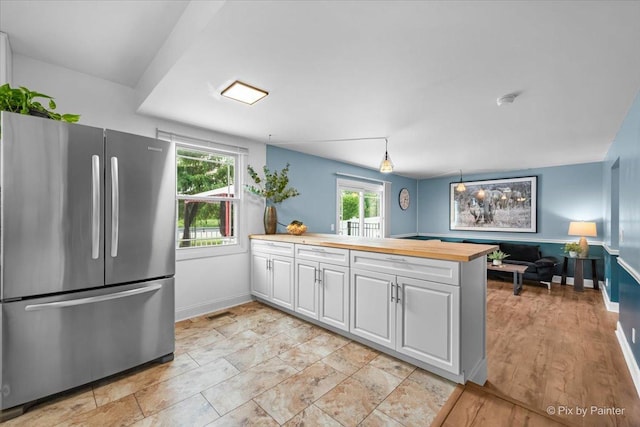 688 Regent Dr, Crystal Lake, IL 60014 - kitchen featuring freestanding refrigerator, plenty of natural light, white cabinets, and wood counters