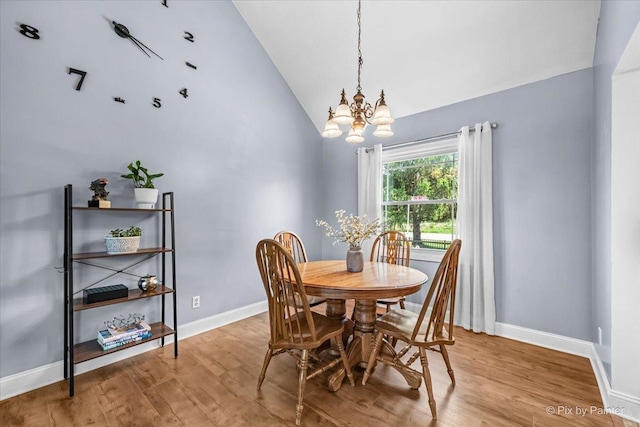 688 Regent Dr, Crystal Lake, IL 60014 - dining space with vaulted ceiling, a chandelier, and wood finished floors