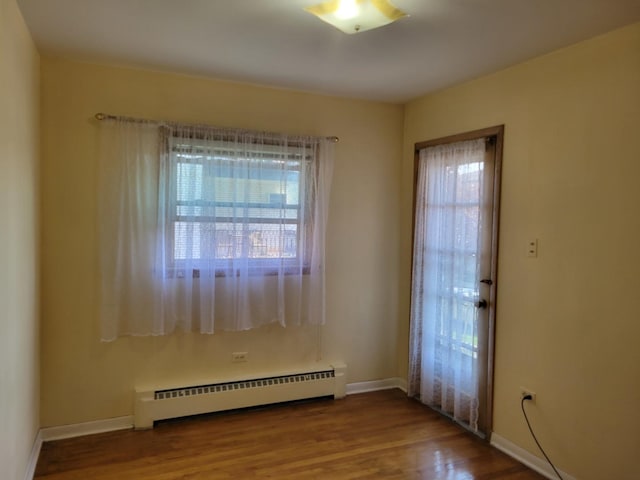 3023 Paris Ave Unit 207, River Grove, IL 60171 - empty room with a baseboard radiator, plenty of natural light, wood finished floors, and baseboards