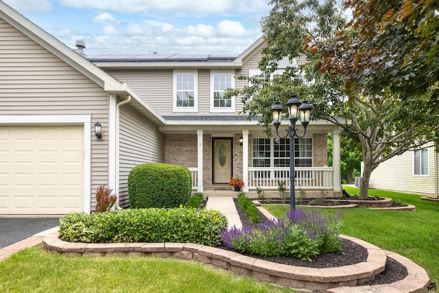 2278 Andrew Trl, Montgomery, IL 60538 - traditional-style house featuring covered porch, brick siding, solar panels, a front lawn, and an attached garage