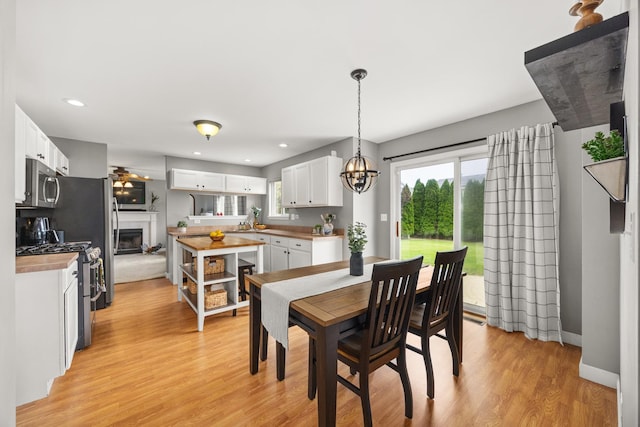 2278 Andrew Trl, Montgomery, IL 60538 - dining area with light wood-style flooring, a fireplace, a chandelier, and recessed lighting
