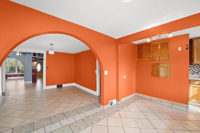 2203 Gilead Ave, Zion, IL 60099 - unfurnished room with light tile patterned floors, arched walkways, baseboards, and ceiling fan
