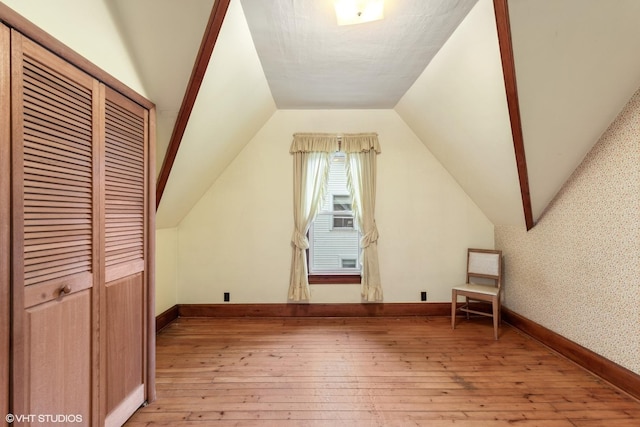 309 E Corning Ave, Peotone, IL 60468 - additional living space with light wood-type flooring, lofted ceiling, and baseboards