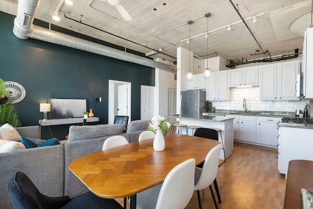 3963 W Belmont Ave Unit 422, Chicago, IL 60618 - dining area with rail lighting, light wood finished floors, and a high ceiling