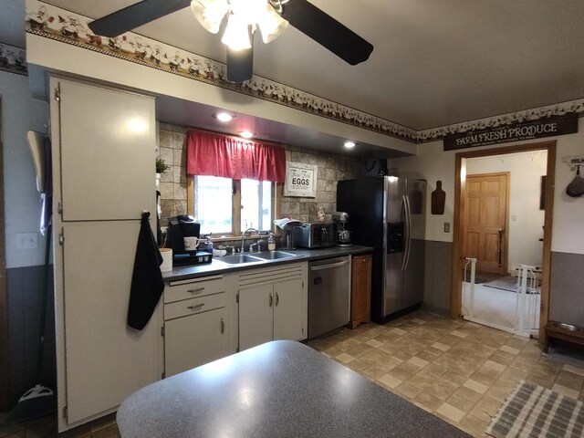 205 Beacon Dr, Belvidere, IL 61008 - kitchen featuring appliances with stainless steel finishes, a sink, dark countertops, ceiling fan, and white cabinetry