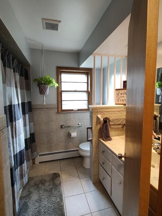 205 Beacon Dr, Belvidere, IL 61008 - full bath featuring a baseboard heating unit, tile walls, tile patterned flooring, vanity, and toilet