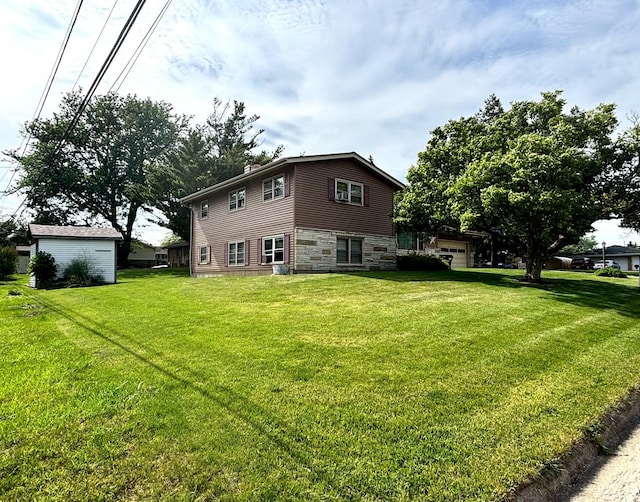 205 Beacon Dr, Belvidere, IL 61008 - back of house featuring stone siding, a lawn, and a chimney
