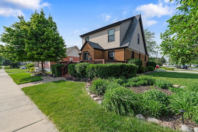 592 E 13th St, Lockport, IL 60441 - view of front of house with brick siding, a front yard, and a wooden deck