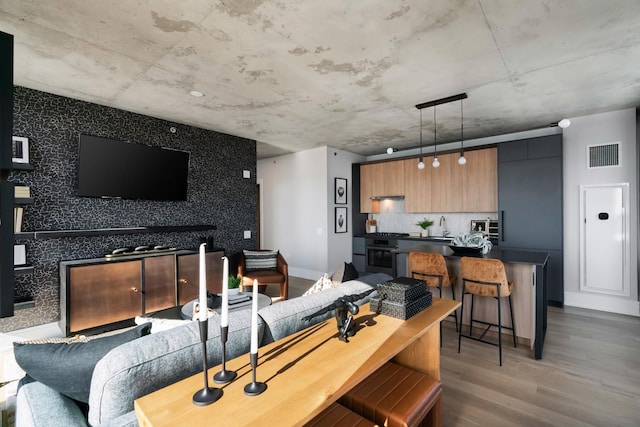 234 W Polk St Unit 3209, Chicago, IL 60607 - living room featuring wood finished floors, an accent wall, and baseboards