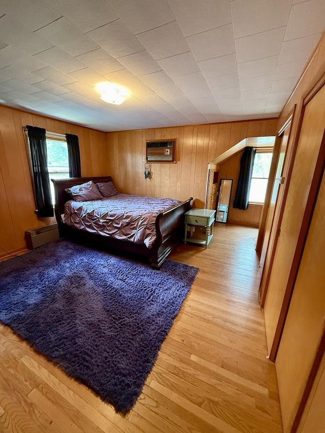 1308 Waverly Pl, Joliet, IL 60435 - bedroom with multiple windows, light wood-type flooring, a wall mounted air conditioner, a baseboard radiator, and wood walls