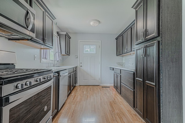1006 Tacoma St, Carpentersville, IL 60110 - kitchen featuring appliances with stainless steel finishes, a sink, light wood-style flooring, light countertops, and baseboards