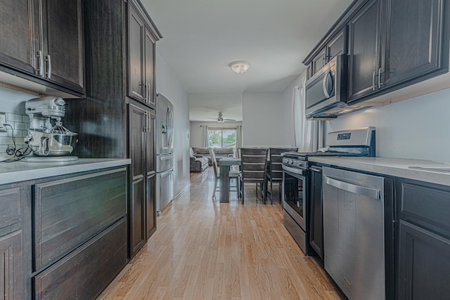 1006 Tacoma St, Carpentersville, IL 60110 - kitchen with appliances with stainless steel finishes, light wood-style floors, light countertops, backsplash, and ceiling fan