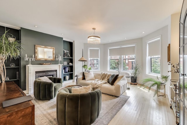 606 W Aldine Ave Unit 3E, Chicago, IL 60657 - living area featuring built in shelves, a fireplace, a chandelier, light wood-style floors, and recessed lighting