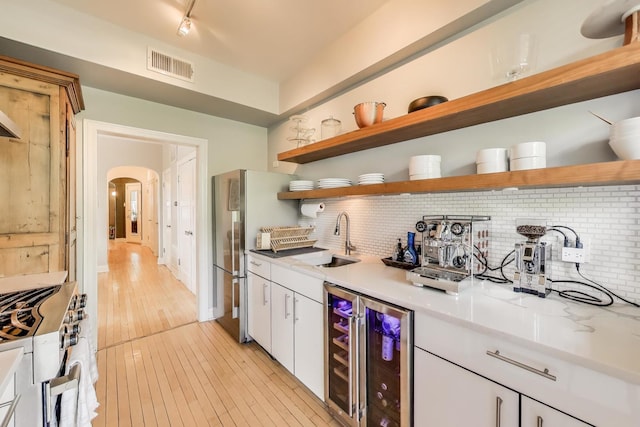 606 W Aldine Ave Unit 3E, Chicago, IL 60657 - kitchen featuring wine cooler, open shelves, range with gas cooktop, and freestanding refrigerator