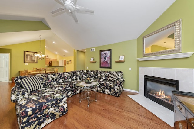 1908 Timbers Edge Cir, Joliet, IL 60431 - living area featuring vaulted ceiling, wood finished floors, ceiling fan, a tiled fireplace, and a chandelier