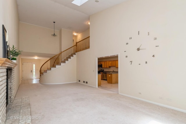 810 Braeman Ct, Libertyville, IL 60048 - unfurnished living room featuring a high ceiling, stairway, light colored carpet, a brick fireplace, and a skylight