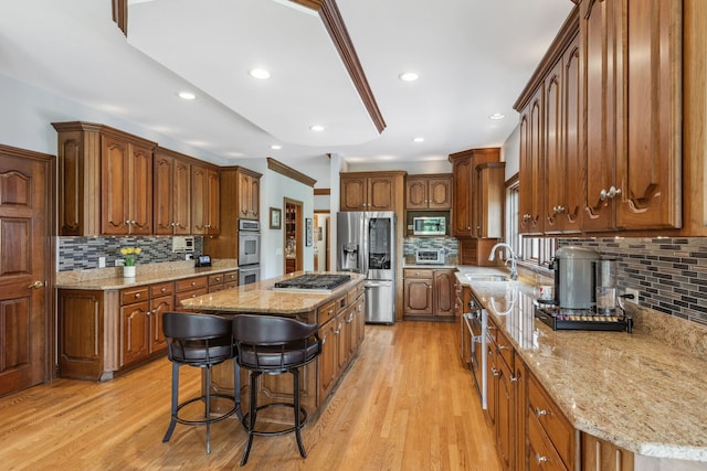 2188 Inverray Rd, Inverness, IL 60067 - kitchen featuring appliances with stainless steel finishes, a sink, a center island, decorative backsplash, and light stone countertops