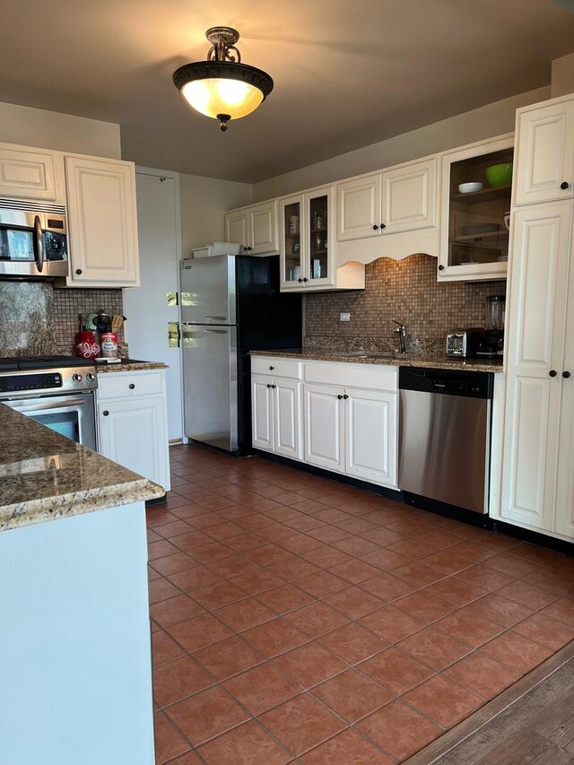 165 N Kenilworth Ave Unit 4D, Oak Park, IL 60301 - kitchen featuring appliances with stainless steel finishes, tasteful backsplash, dark tile patterned floors, white cabinets, and dark stone countertops