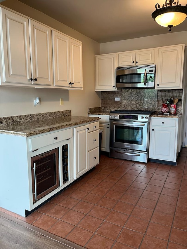 165 N Kenilworth Ave Unit 4D, Oak Park, IL 60301 - kitchen featuring stainless steel appliances, white cabinetry, decorative backsplash, and dark tile patterned floors