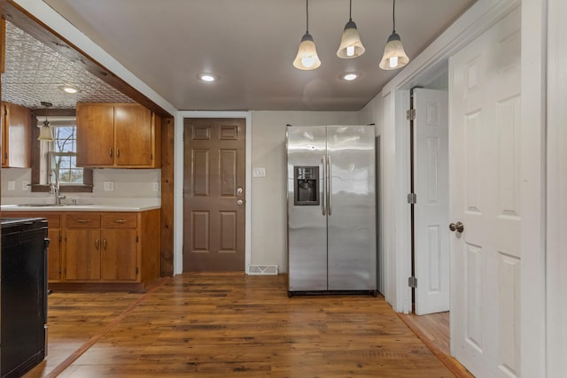 201 S 1st St, Tolono, IL 61880 - kitchen with stainless steel fridge with ice dispenser, a sink, light countertops, brown cabinets, and recessed lighting