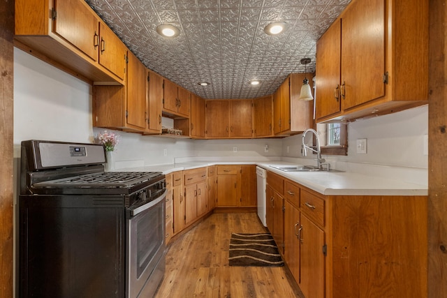 201 S 1st St, Tolono, IL 61880 - kitchen with stainless steel range with gas cooktop, light wood finished floors, a sink, an ornate ceiling, and brown cabinetry