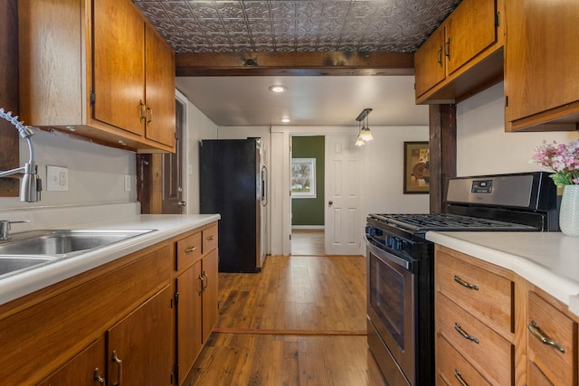 201 S 1st St, Tolono, IL 61880 - kitchen featuring stainless steel appliances, an ornate ceiling, brown cabinets, hardwood / wood-style floors, and light countertops