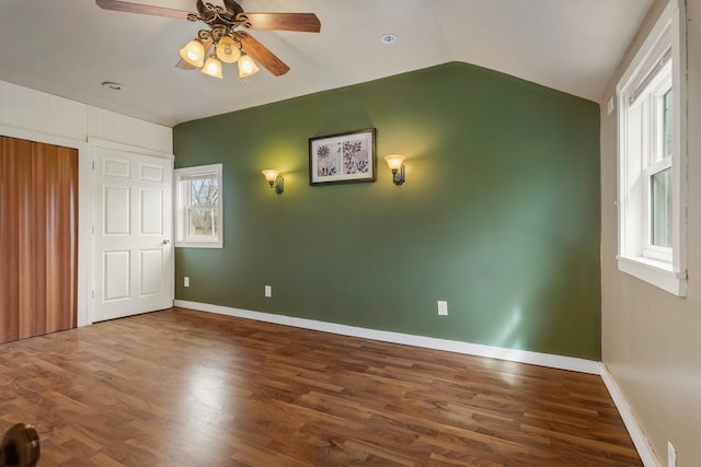 201 S 1st St, Tolono, IL 61880 - unfurnished bedroom featuring wood finished floors, baseboards, vaulted ceiling, and a ceiling fan