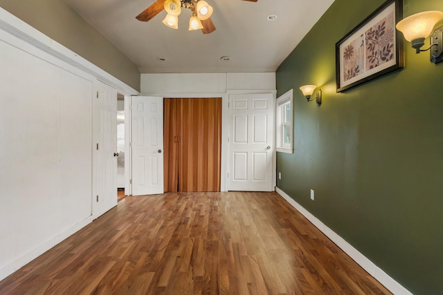 201 S 1st St, Tolono, IL 61880 - unfurnished bedroom featuring wood finished floors, baseboards, and ceiling fan
